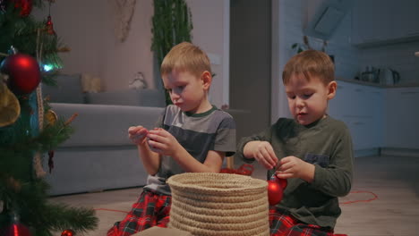 Two-boys-3-5-years-old-together-decorate-the-Christmas-tree-before-Christmas.-together-decorating-the-house.-High-quality-4k-footage